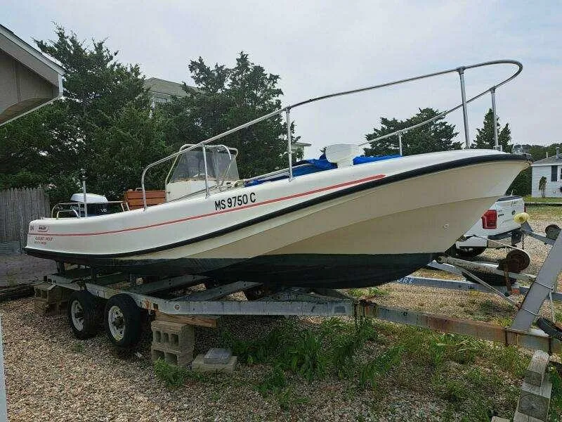 Slide: The Image of 1973 Boston Whaler 21 Outrage boat on trailer, parked outdoors. - 3