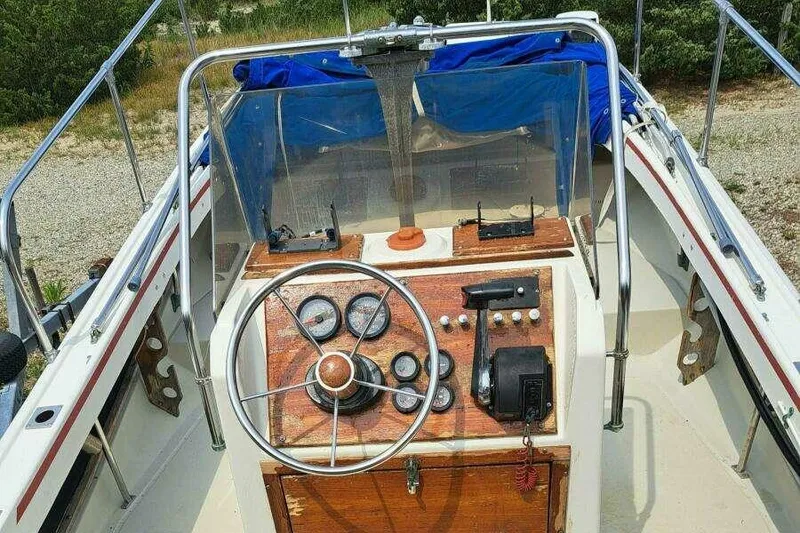 Slide: The Image of 1973 Boston Whaler 21 Outrage boat dashboard with steering wheel and gauges. - 4