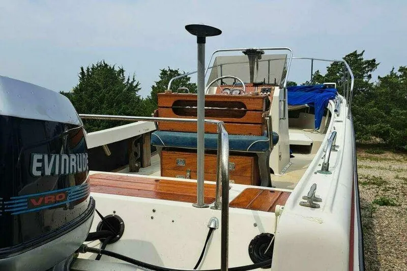 Slide: The Image of 1973 Boston Whaler 21 Outrage boat with Evinrude engine, docked outdoors. - 8