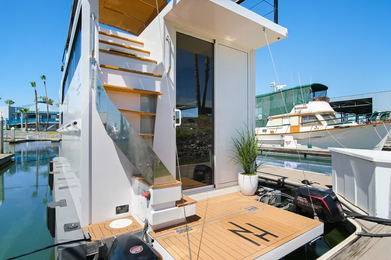 Slide: The Image of Modern 2024 Navisyo Homes 28' NAVIS V.08 houseboat docked with sleek design and outdoor stairs. - 10