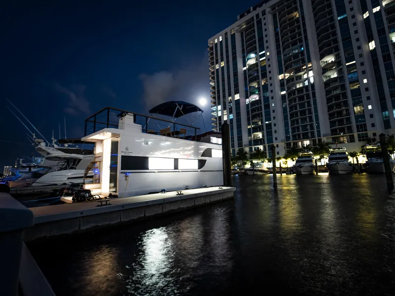 Slide: The Image of 2024 Navisyo Homes 28' NAVIS V.08 houseboat docked at night near illuminated buildings. - 25