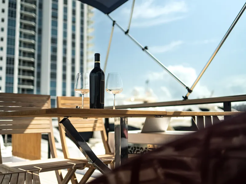 Slide: The Image of Outdoor dining setup on 2024 Navisyo Homes 28' NAVIS V.08 yacht with wine and glasses. - 28