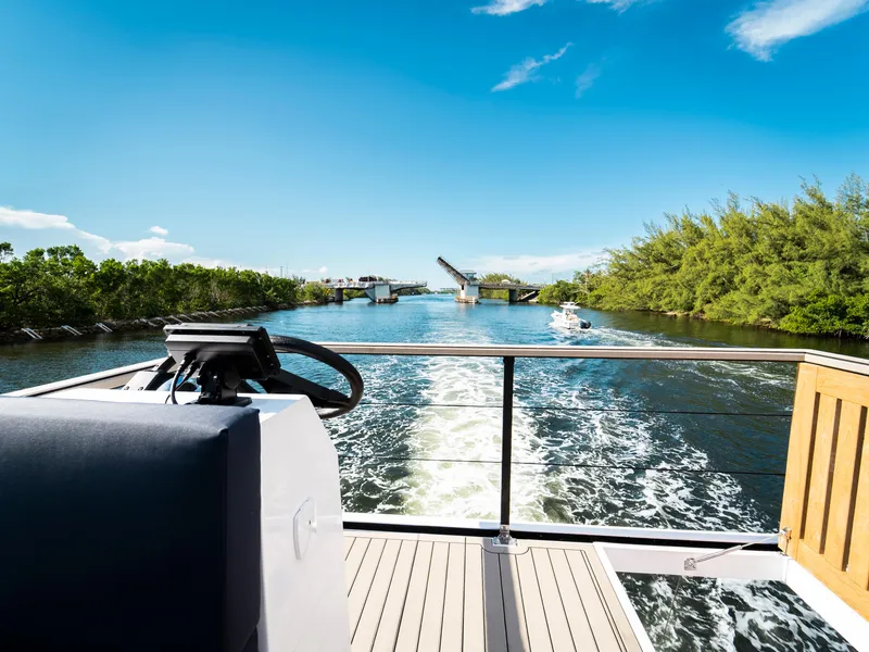 Slide: The Image of 2024 Navisyo Homes 28' NAVIS V.08 cruising on a scenic waterway. - 32