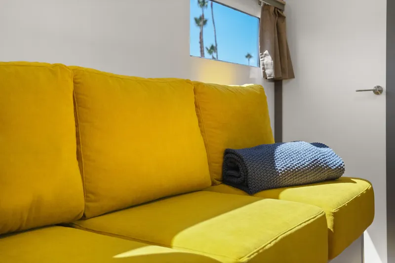 Slide: The Image of Yellow sofa with blue blanket in 2024 Navisyo Homes 28' NAVIS V.08 interior. - 38