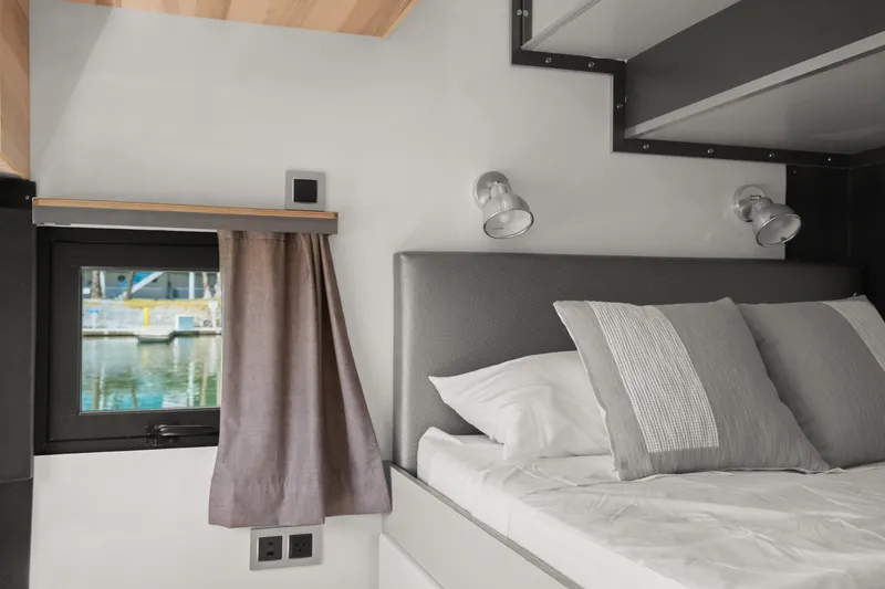 Slide: The Image of Modern bedroom interior in 2024 Navisyo Homes 28' NAVIS V.08, featuring cozy bed and window view. - 41