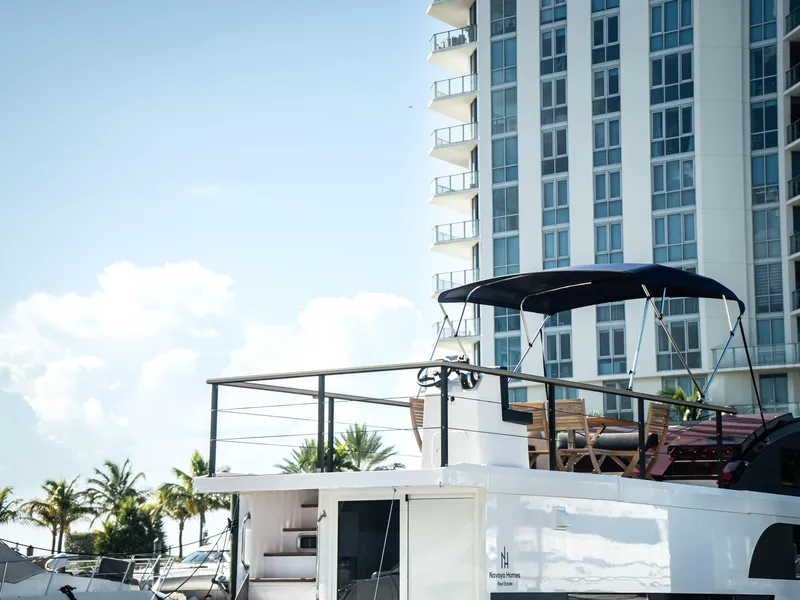 Slide: The Image of 2024 Navisyo Homes 28' NAVIS V.08 houseboat docked near modern high-rise building. - 14