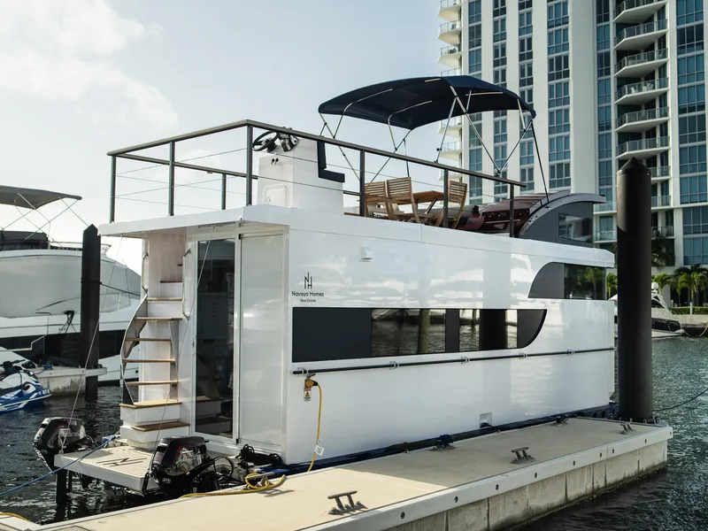 Slide: The Image of Modern 2024 Navisyo Homes 28' NAVIS V.08 houseboat docked by waterfront skyscrapers. - 24