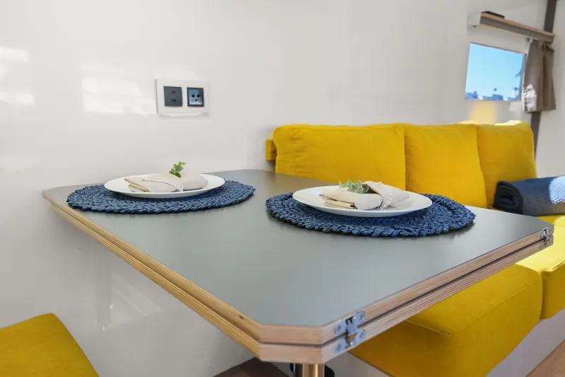 Slide: The Image of Modern interior of 2024 Navisyo Homes 28' NAVIS V.08 with yellow seating and dining table. - 35