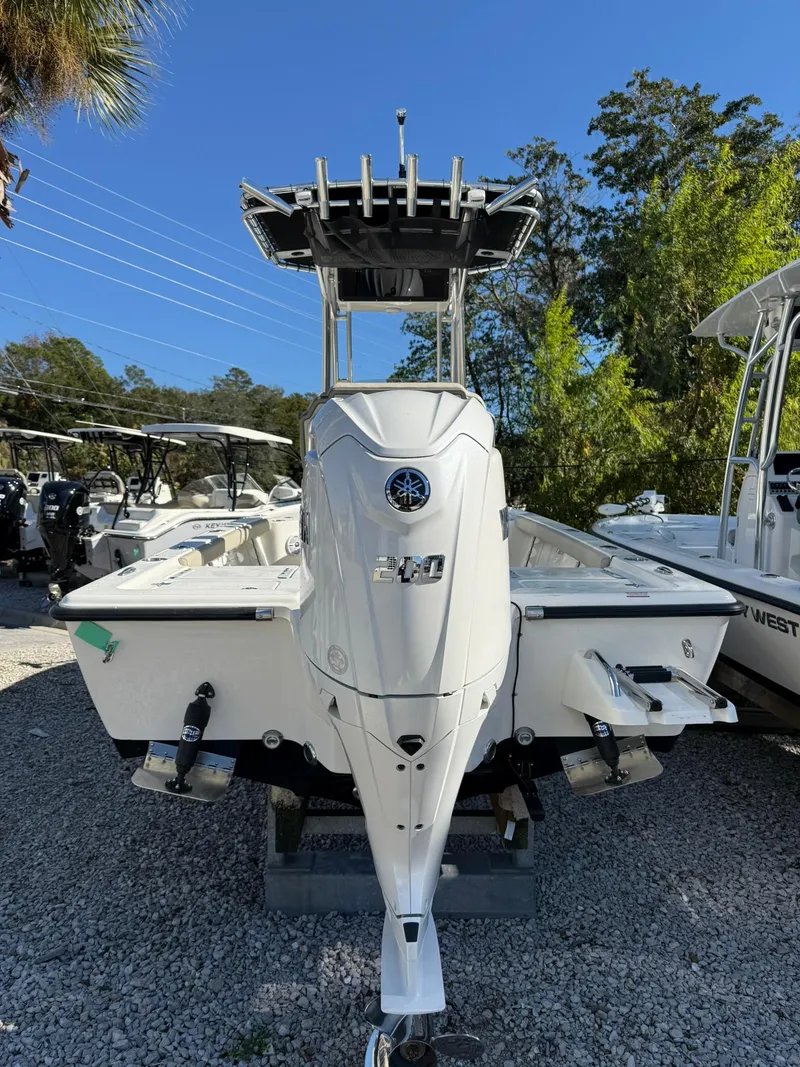 Slide: The Image of 2025 Key West 210 Bay Reef boat, white, parked outdoors on gravel. - 2