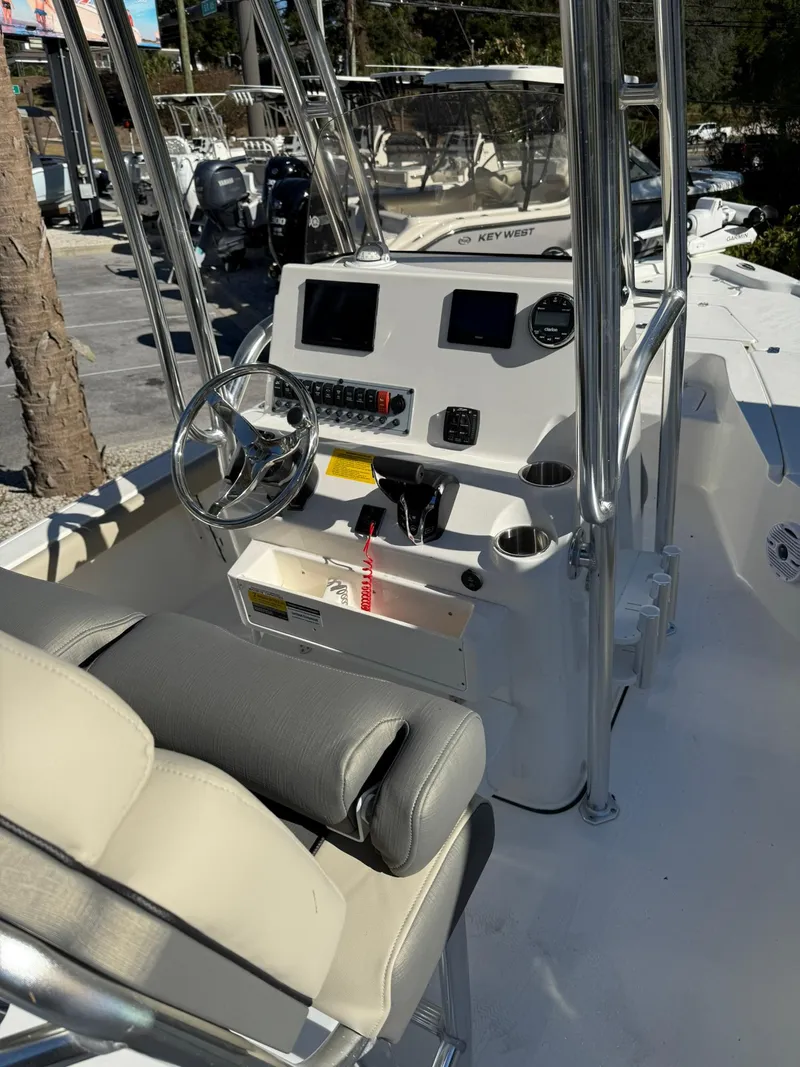 Slide: The Image of 2025 Key West 210 Bay Reef boat console with steering wheel and navigation controls. - 5