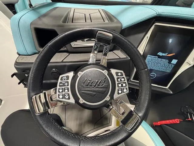 Slide: The Image of 2020 Tigé 20RZX boat steering wheel with control buttons and digital display. - 16