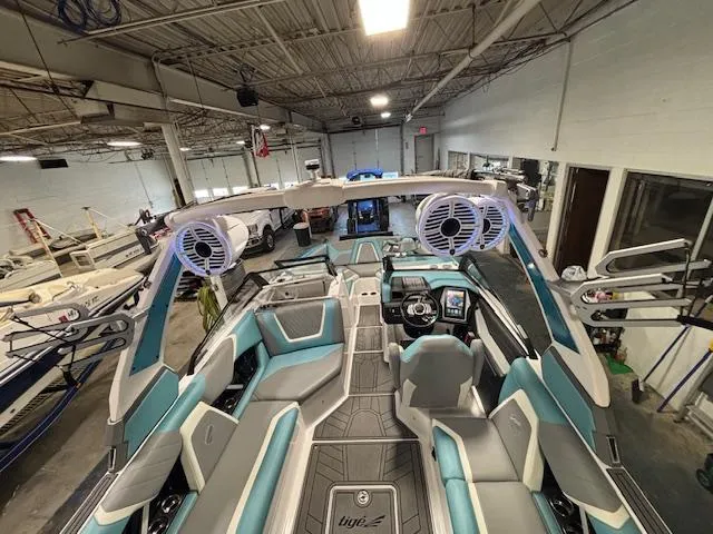 Slide: The Image of 2020 Tigé 20RZX boat interior with teal and gray seating in a workshop. - 23