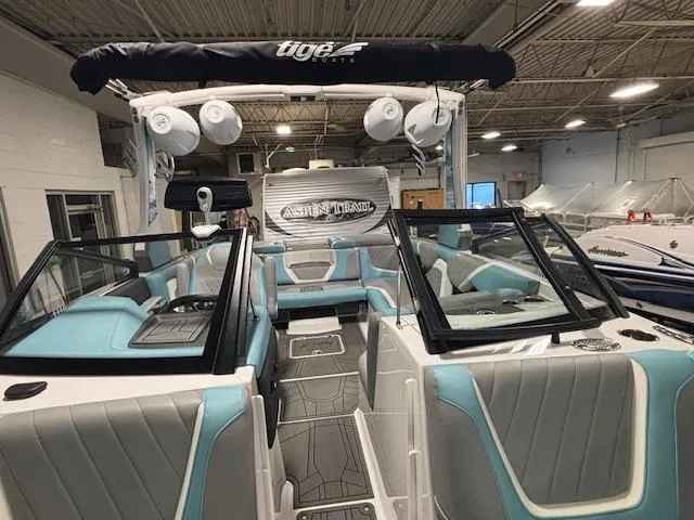 Slide: The Image of 2020 Tigé 20RZX boat interior with teal and gray seating in showroom. - 29