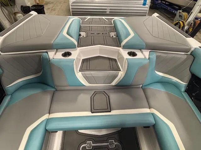 Slide: The Image of 2020 Tigé 20RZX boat interior with gray and teal seating, cup holders, and storage compartments. - 35