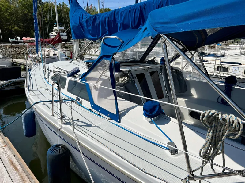 Slide: The Image of Catalina 320 sailboat from 2000 docked with blue covers and ropes. - 11