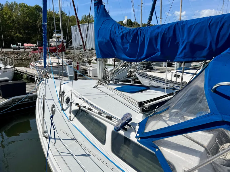 Slide: The Image of Sailboat Catalina 320, 2000 model, docked at marina with blue covers. - 12