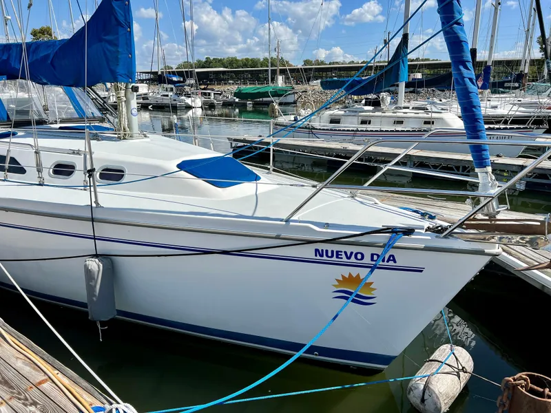 Slide: The Image of Catalina 320 sailboat docked at marina, featuring blue accents and sunny weather. - 14