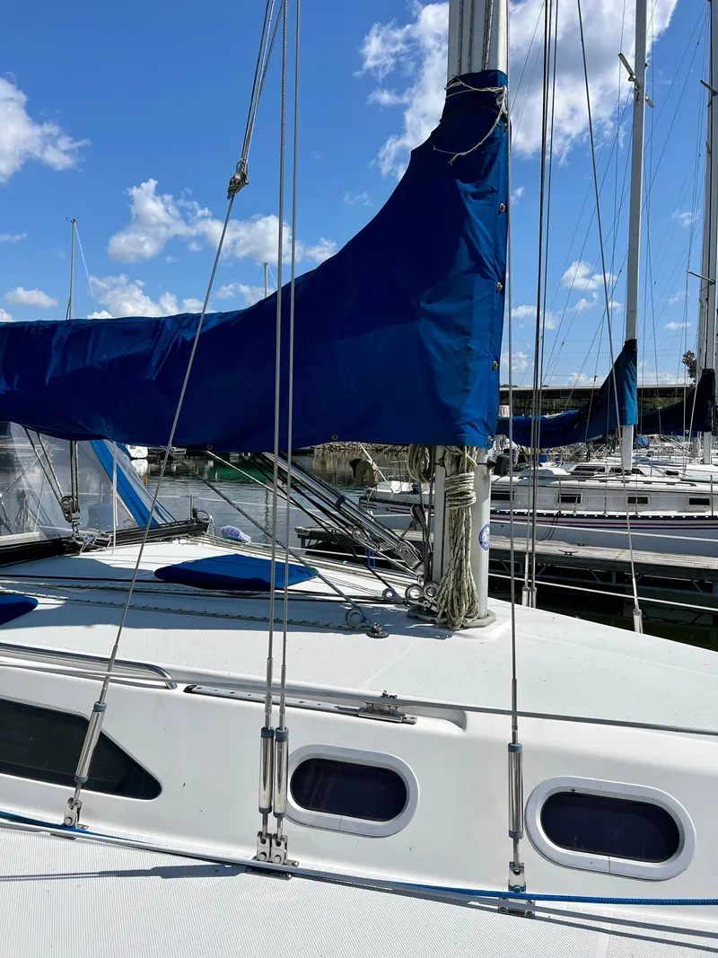 Slide: The Image of Sailboat Catalina 320, 2000 model, docked with blue sail cover, under clear sky. - 17