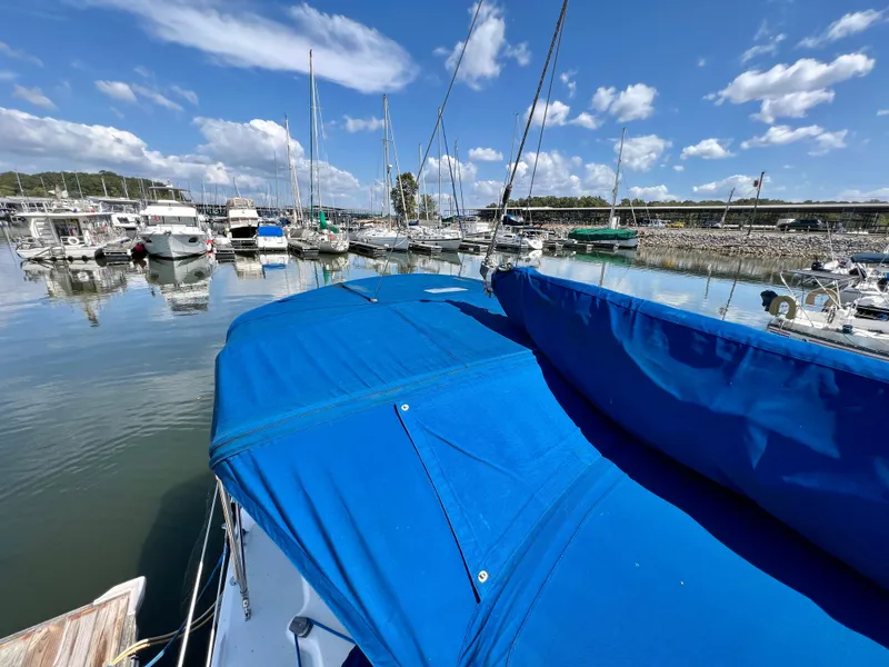 Slide: The Image of Catalina 320 sailboat docked in marina, blue cover, clear sky, 2000 model. - 19