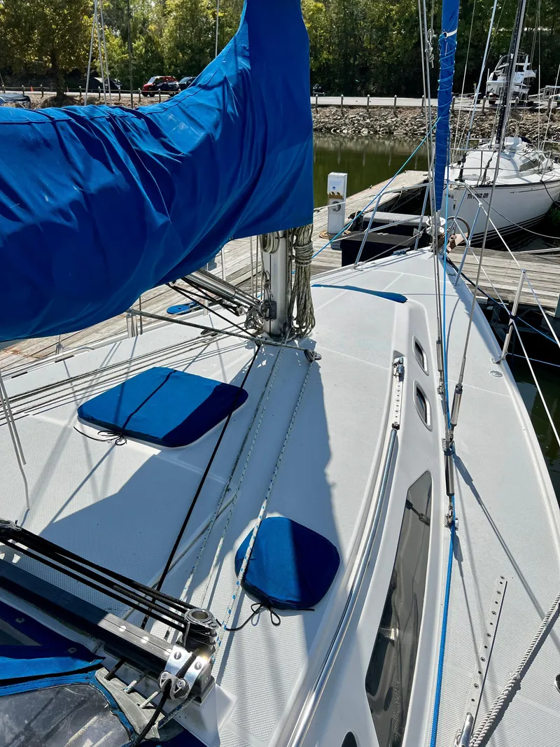 Slide: The Image of 2000 Catalina 320 sailboat deck with blue sail cover, docked at marina. - 25