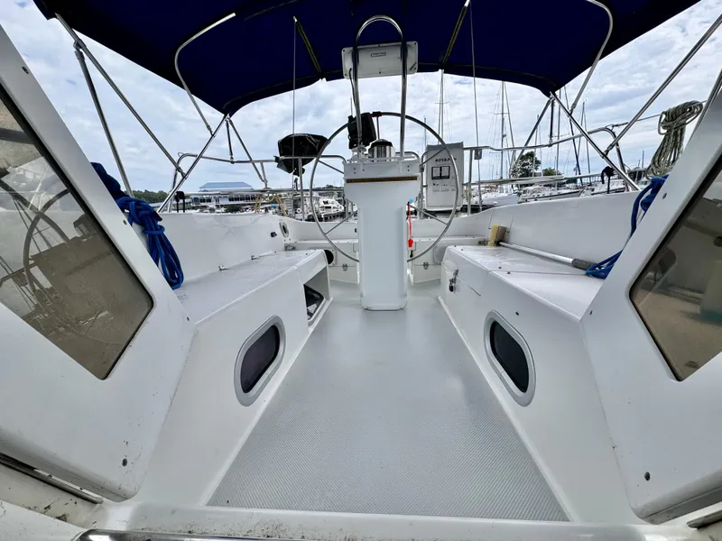 Slide: The Image of Cockpit of a 2000 Catalina 320 sailboat with blue canopy and steering wheel. - 28