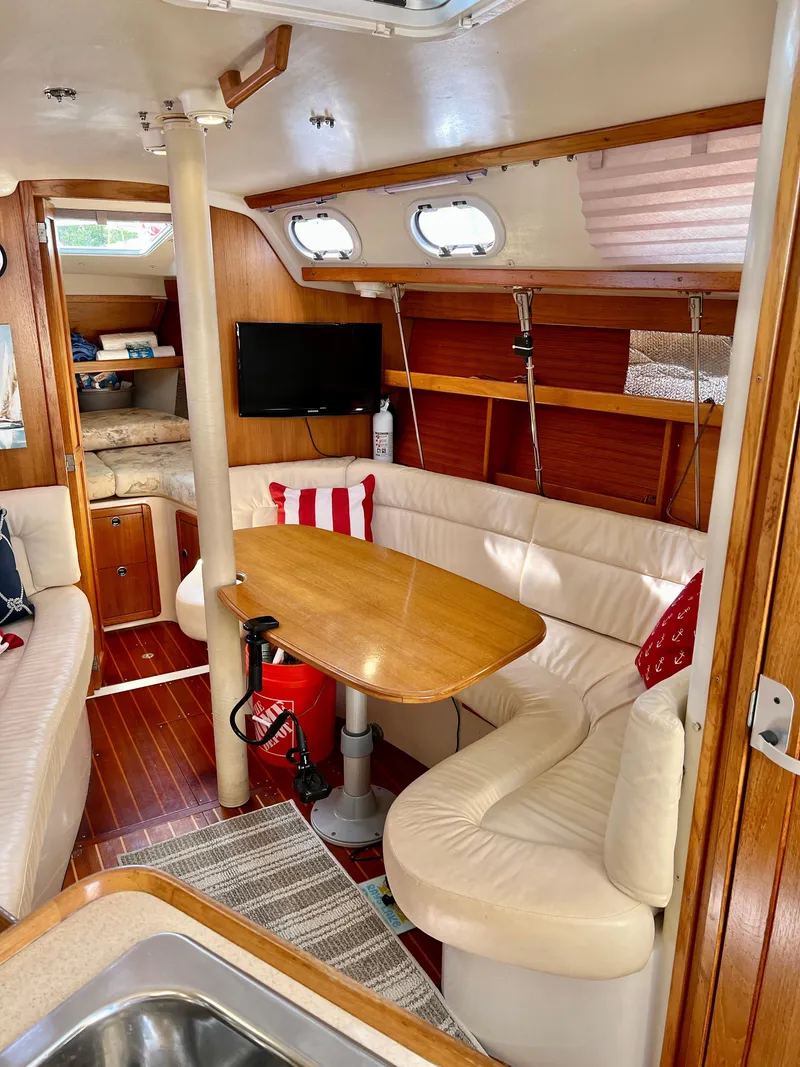 Slide: The Image of Interior of a 2000 Catalina 320 sailboat with cozy seating and wooden accents. - 34