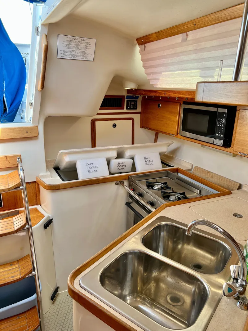 Slide: The Image of Interior of a 2000 Catalina 320 sailboat kitchen with stove, sink, and microwave. - 36
