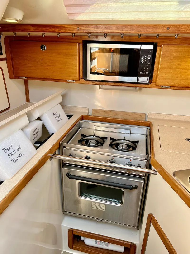 Slide: The Image of Compact kitchen in 2000 Catalina 320 sailboat with stove, microwave, and storage. - 38