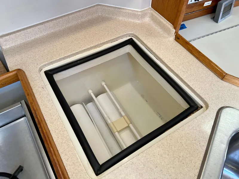 Slide: The Image of Catalina 320 (2000) boat interior with open storage compartment in kitchen area. - 40