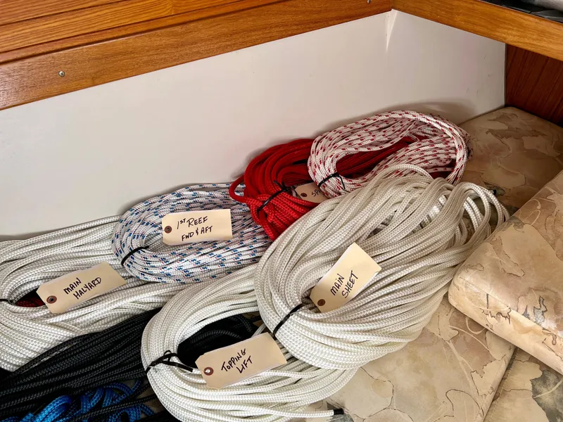 Slide: The Image of Coiled sailing ropes labeled for Catalina 320, 2000 model, organized on a boat interior. - 45