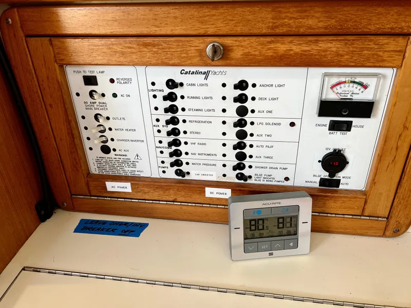 Slide: The Image of Electrical control panel of a 2000 Catalina 320 yacht with various switches and gauges. - 48