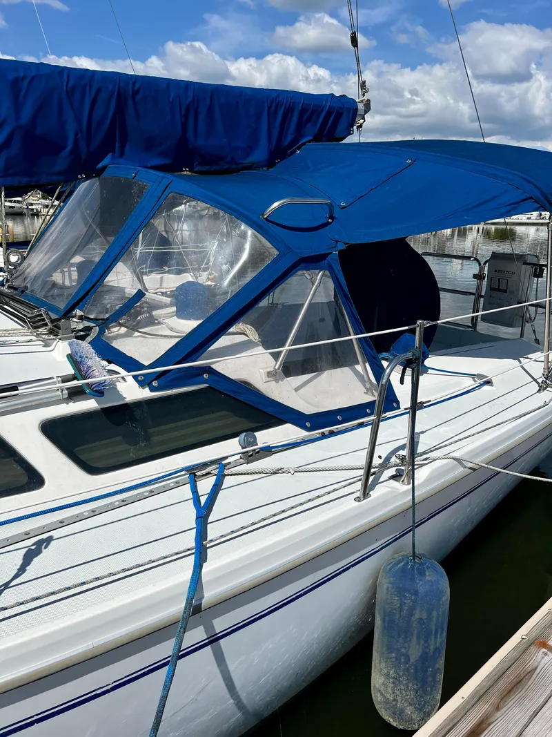 Slide: The Image of Catalina 320 sailboat, 2000 model, docked with blue canopy and clear windows. - 7
