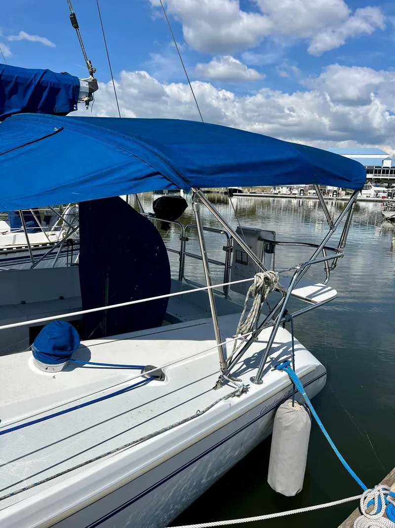 Slide: The Image of 2000 Catalina 320 sailboat docked with blue canopy and clear sky background. - 8