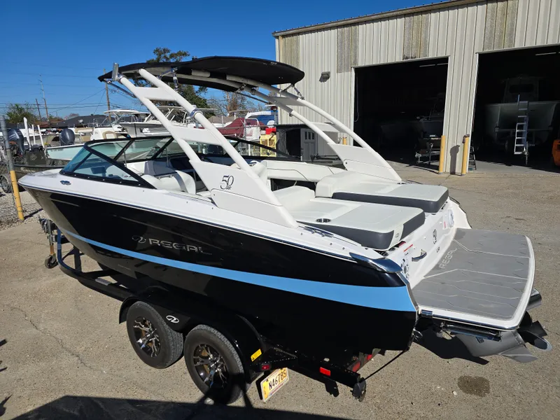 Slide: The Image of 2021 Regal LS2 boat on trailer, parked outdoors near a warehouse. - 20