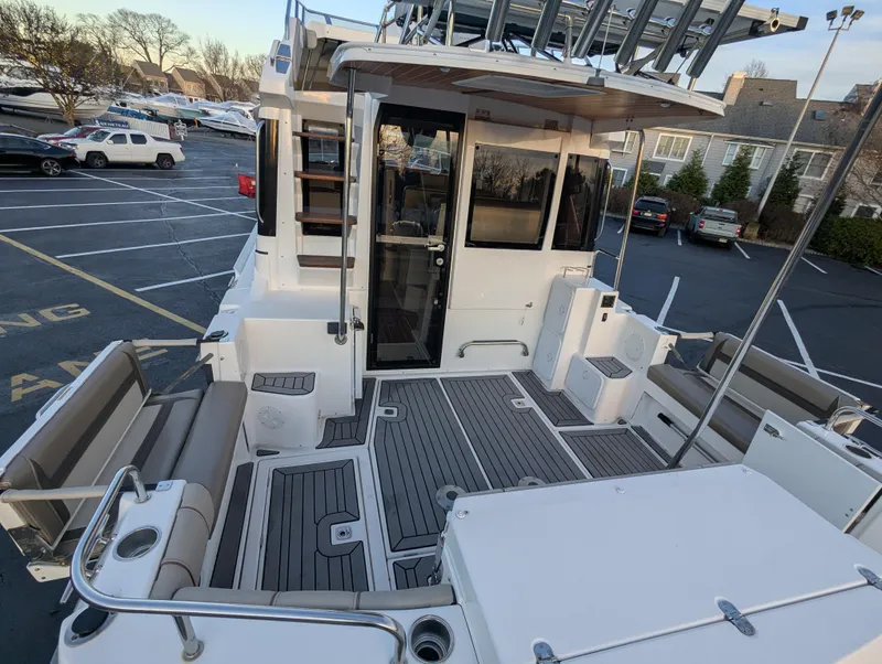 Slide: The Image of 2022 Cutwater C-32 CB boat with spacious deck and seating in a parking lot. - 22