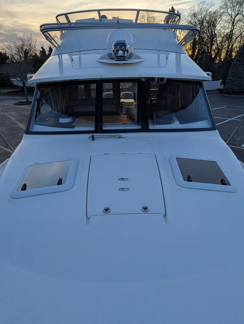 Slide: The Image of 2022 Cutwater C-32 CB boat, front view at sunset, parked on a lot. - 32