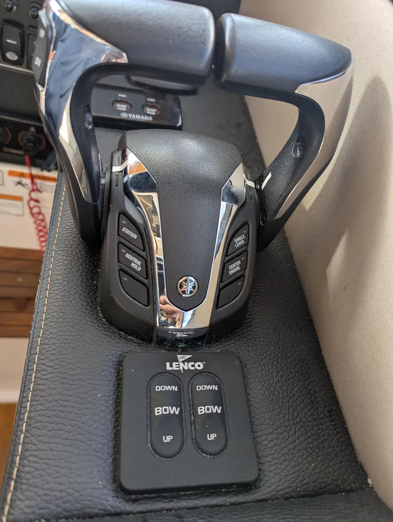 Slide: The Image of Throttle controls and trim tab switches on a 2022 Cutwater C-32 CB boat. - 46