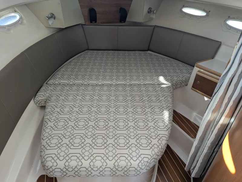 Slide: The Image of 2022 Cutwater C-32 CB cabin interior with patterned bed and wood accents. - 49