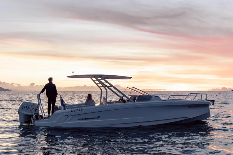 Slide: The Image of 2025 Axopar AX/E 25 electric boat interior with EVOY® STORM engines, featuring comfortable seating and scenic water view. - 13