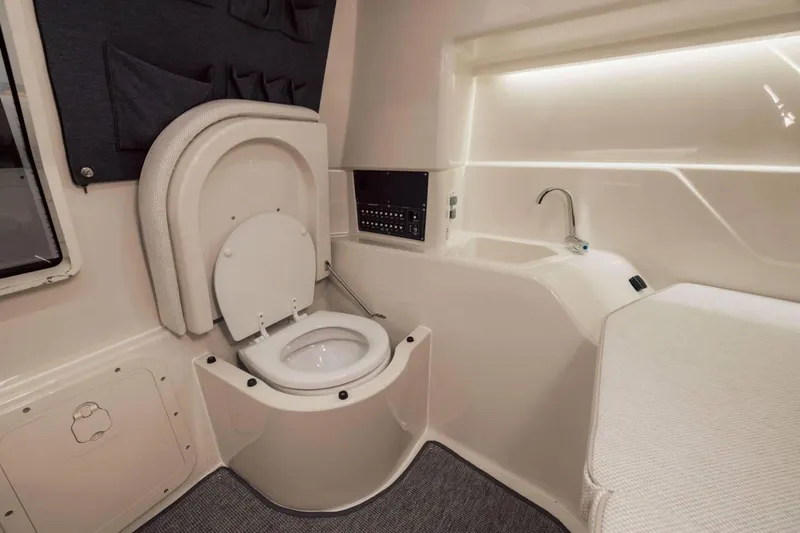 Slide: The Image of 2025 Axopar AX/E 25 boat interior with modern toilet and sink. - 16