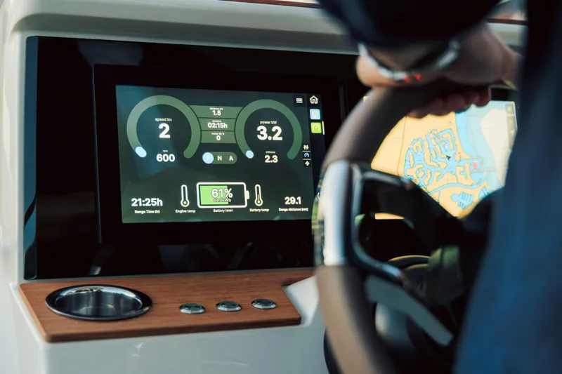 Slide: The Image of 2025 Axopar AX/E 25 electric boat with EVOY® STORM engines in urban harbor setting. - 6