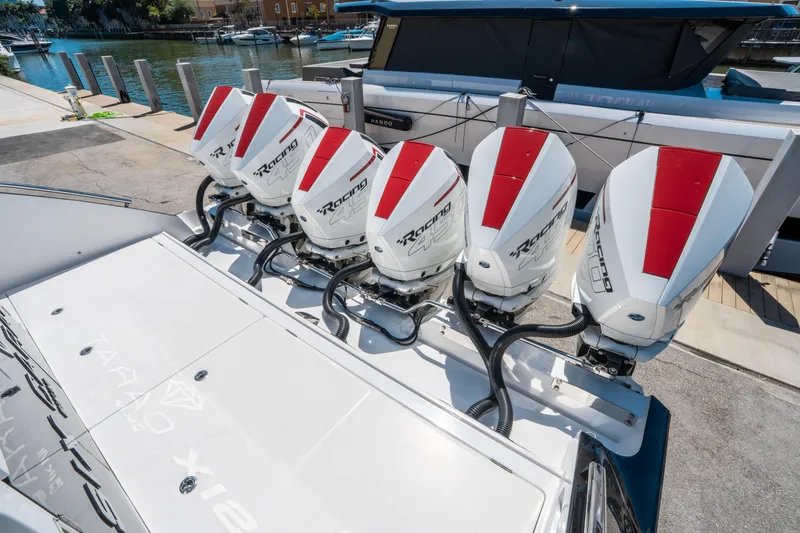 Slide: The Image of Five powerful outboard engines on a 2021 Cigarette 59 Tirranna boat docked at a marina. - 14