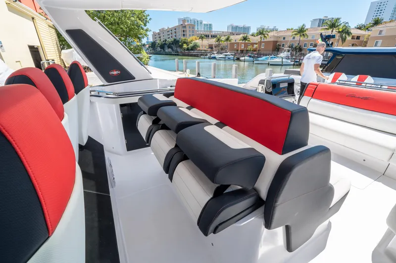 Slide: The Image of 2021 Cigarette 59 Tirranna luxury boat interior with red and black seating, docked by waterfront. - 28