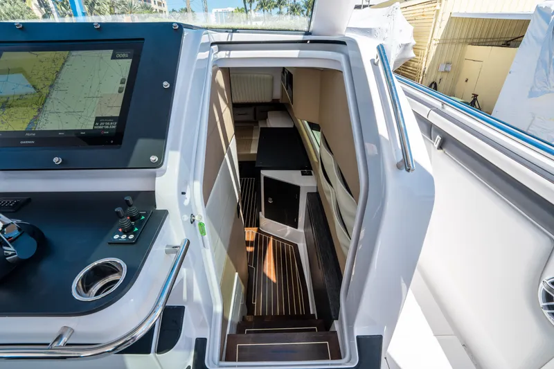 Slide: The Image of Interior view of 2021 Cigarette 59 Tirranna yacht, featuring navigation controls and cabin entrance. - 36