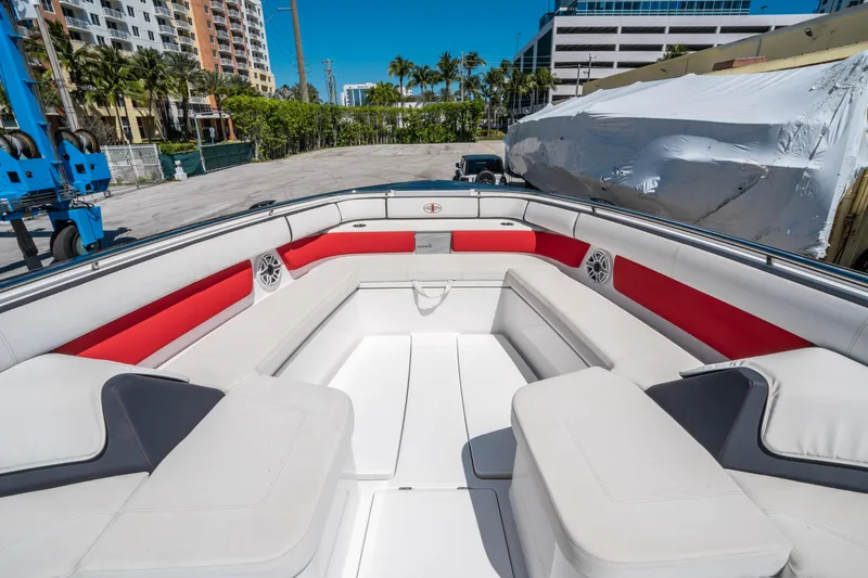 Slide: The Image of 2021 Cigarette 59 Tirranna boat interior with red and white seating, docked outdoors. - 47