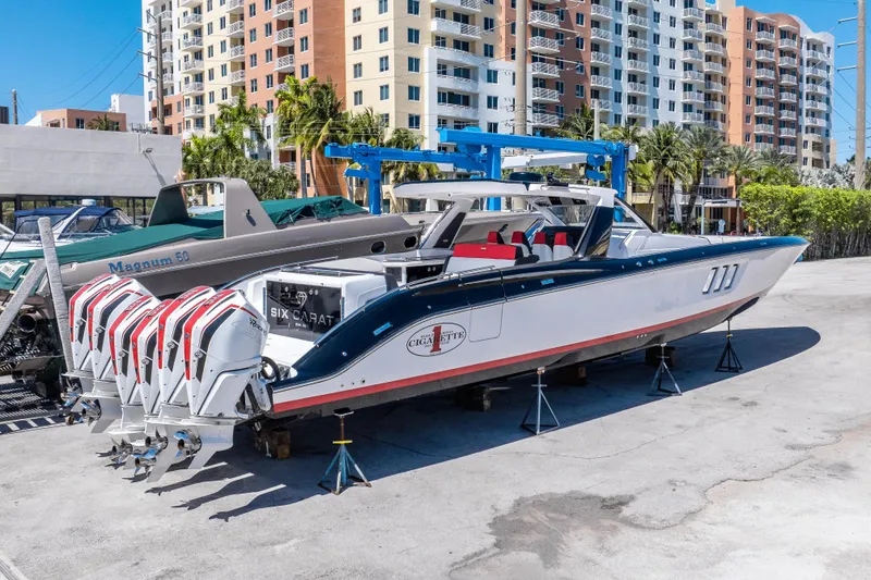 Slide: The Image of 2021 Cigarette 59 Tirranna boat with multiple engines, parked in an urban marina setting. - 7