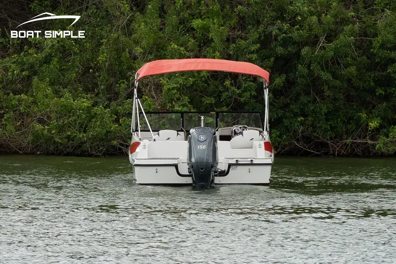 Slide: The Image of 2024 Starcraft SVX 190 OB DC boat with red canopy on a lake. - 2