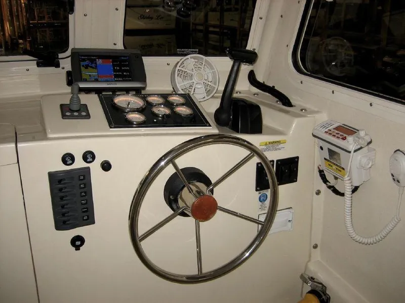 Slide: The Image of 2008 Eastern 27 boat helm with steering wheel, gauges, and navigation equipment. - 6