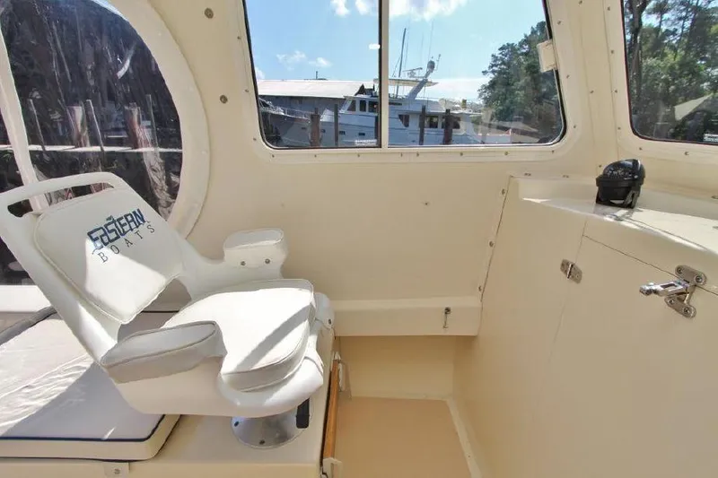 Slide: The Image of Interior of 2008 Eastern 27 boat with white captain's chair and window view. - 7