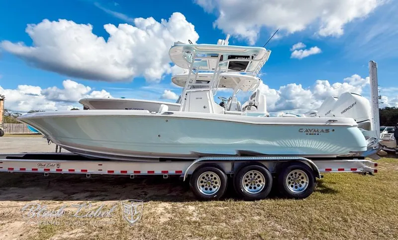 Slide: The Image of 2025 Caymas 281 HB boat on trailer under a blue sky with clouds. - 1
